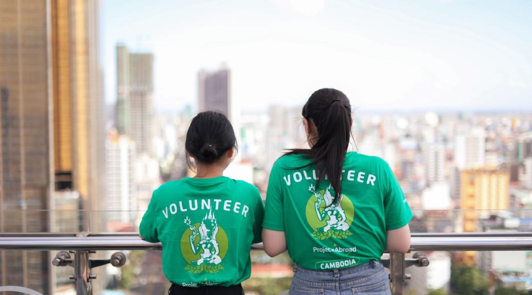 Two Projects Abroad volunteers gaze across the Phnom Penh cityscape from a viewing platform 