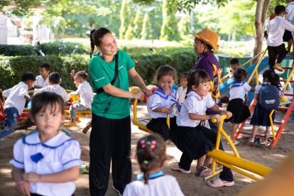A volunteer in a park with children in Cambodia.