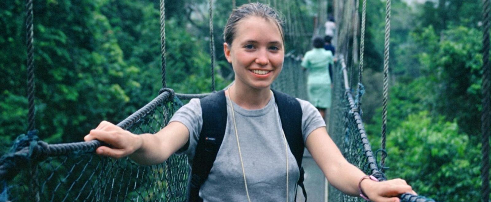 A participant looks at the camera while walking on a rope bridge in Ghana