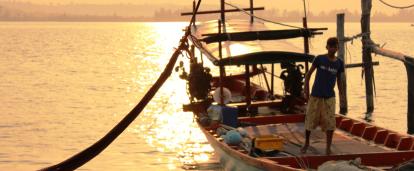 A local fisherman prepares a boat for a group of volunteers on a trip to experience Khmer cultural immersion. 