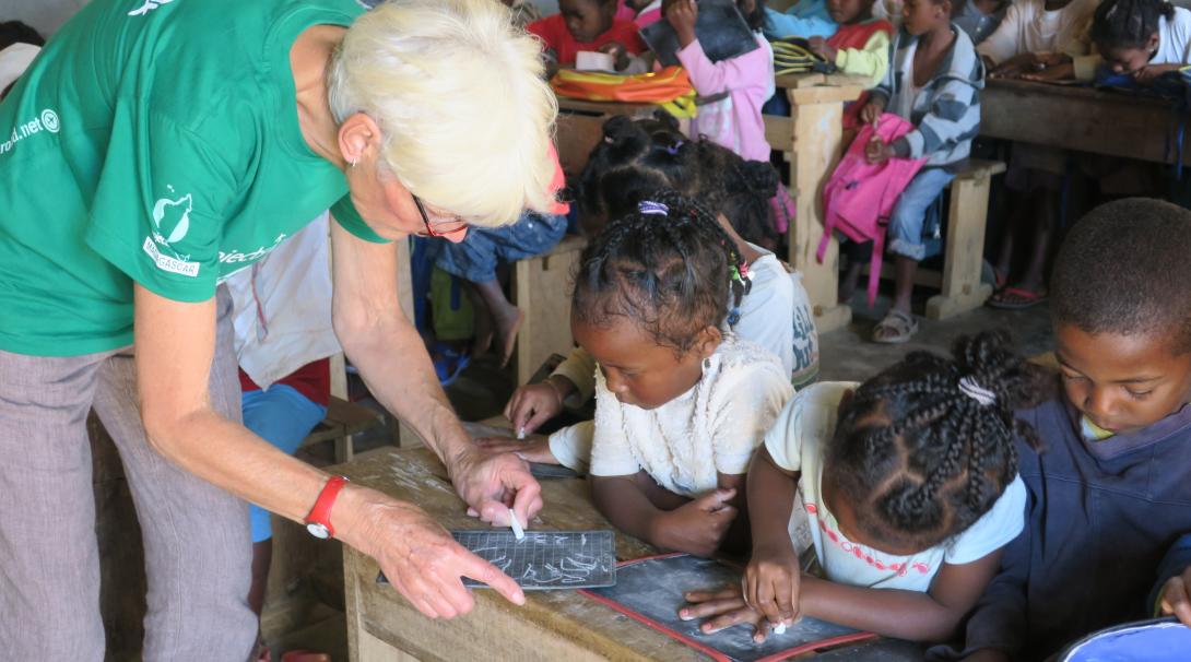 On a volunteer abroad program for older adults, a woman works with school children in Madagascar.