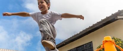 A young boy jumps over a rope during one of our Sports volunteering opportunities.