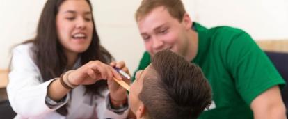 A local child has his teeth checked by two students doing a Dentistry internship in Mexico. 