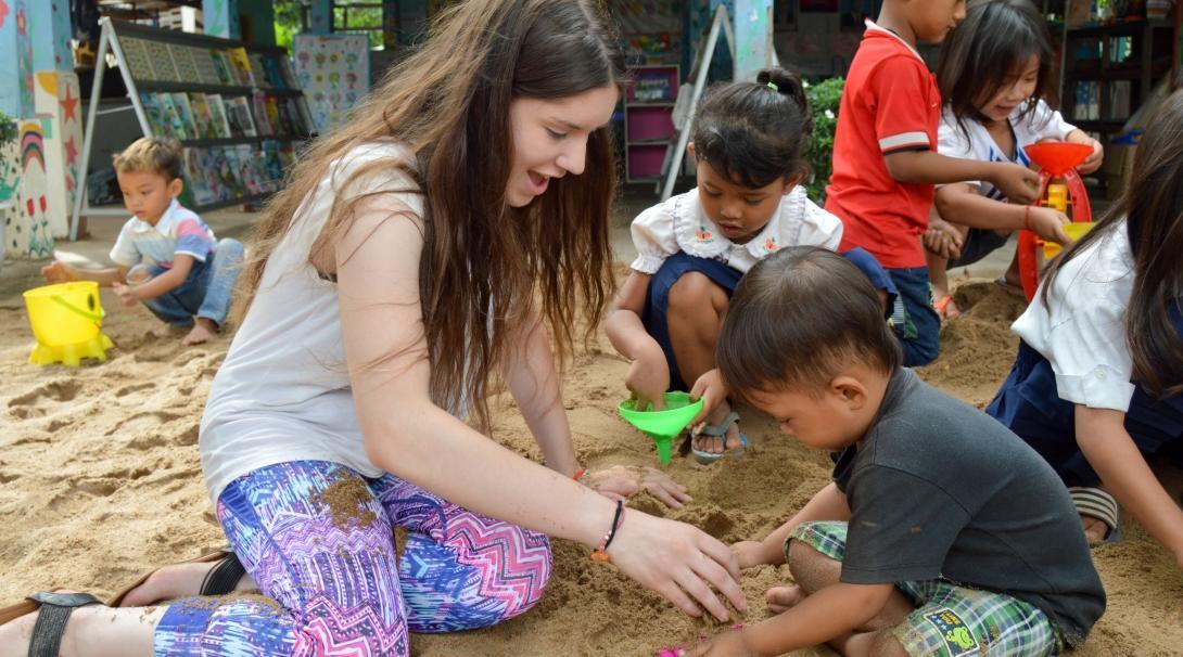 A volunteers spends time with the children in Cambodia after joining volunteering opportunities for high school students with Projects Abroad. 