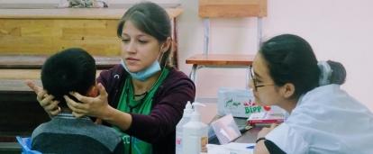 Un enfant se fait ausculter par une stagiaire en soins infirmiers à l'occasion d'une campagne de soins gratuite au Vietnam. 