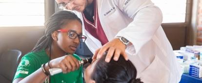 A Projects Abroad intern assists with checking a patient to gain internship work experience overseas. 