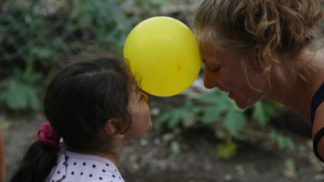 In Costa Rica on a spring break community service trip, a student and child play an Early Childhood Development game with a balloon. 