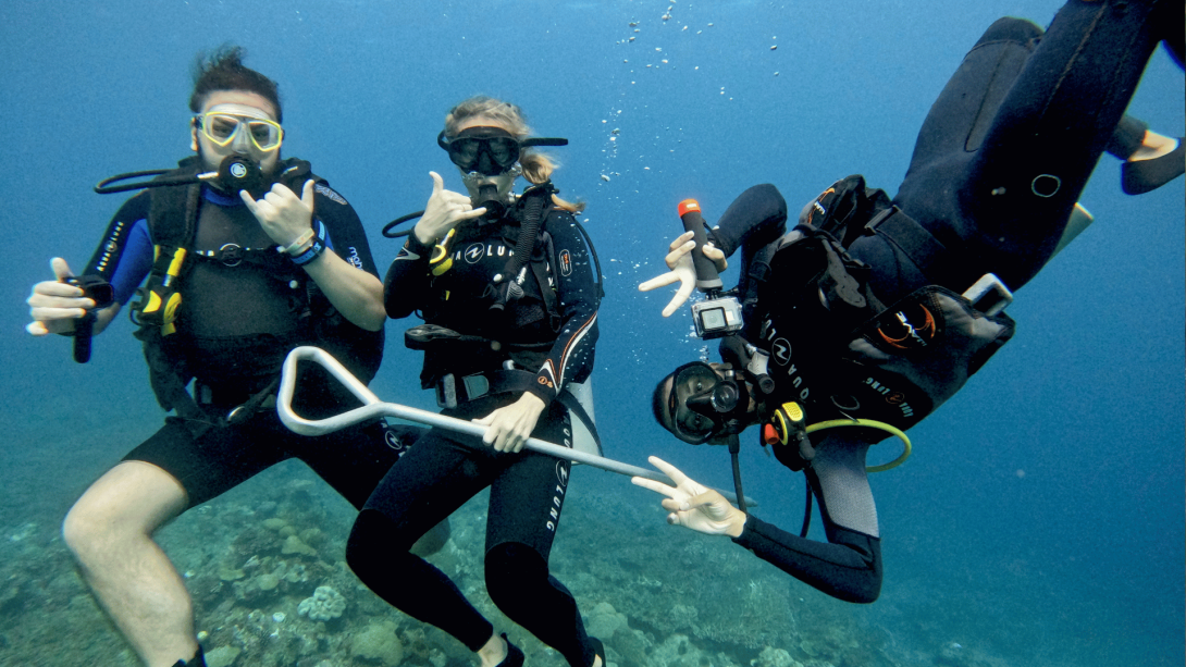 Three Projects Abroad divers have fun in Fiji, posing for the camera while conducting coral reef surveys underwater