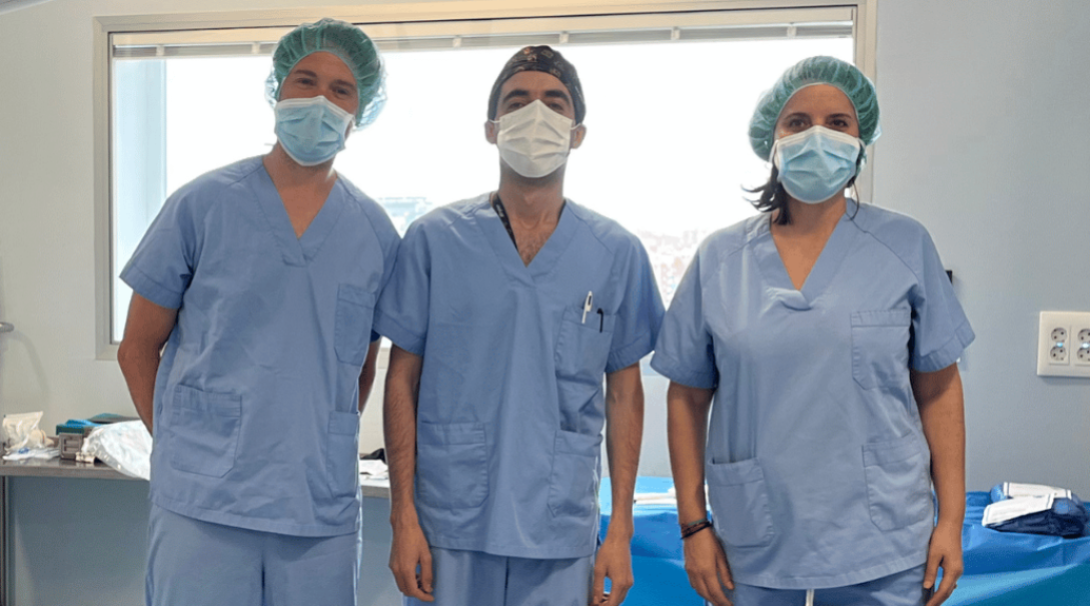 Pre-Med intern wears scrubs next to surgeon in the operating theatre